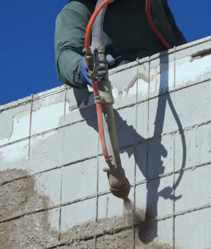 Chapisco sendo projetado na parede com a pistola